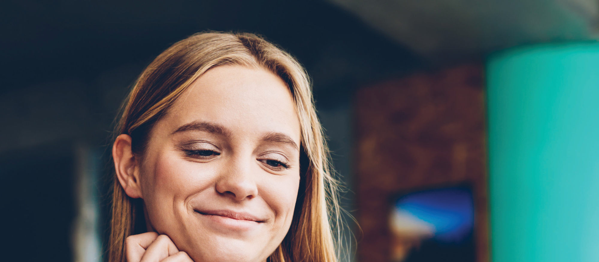 A woman smiling at her laptop
